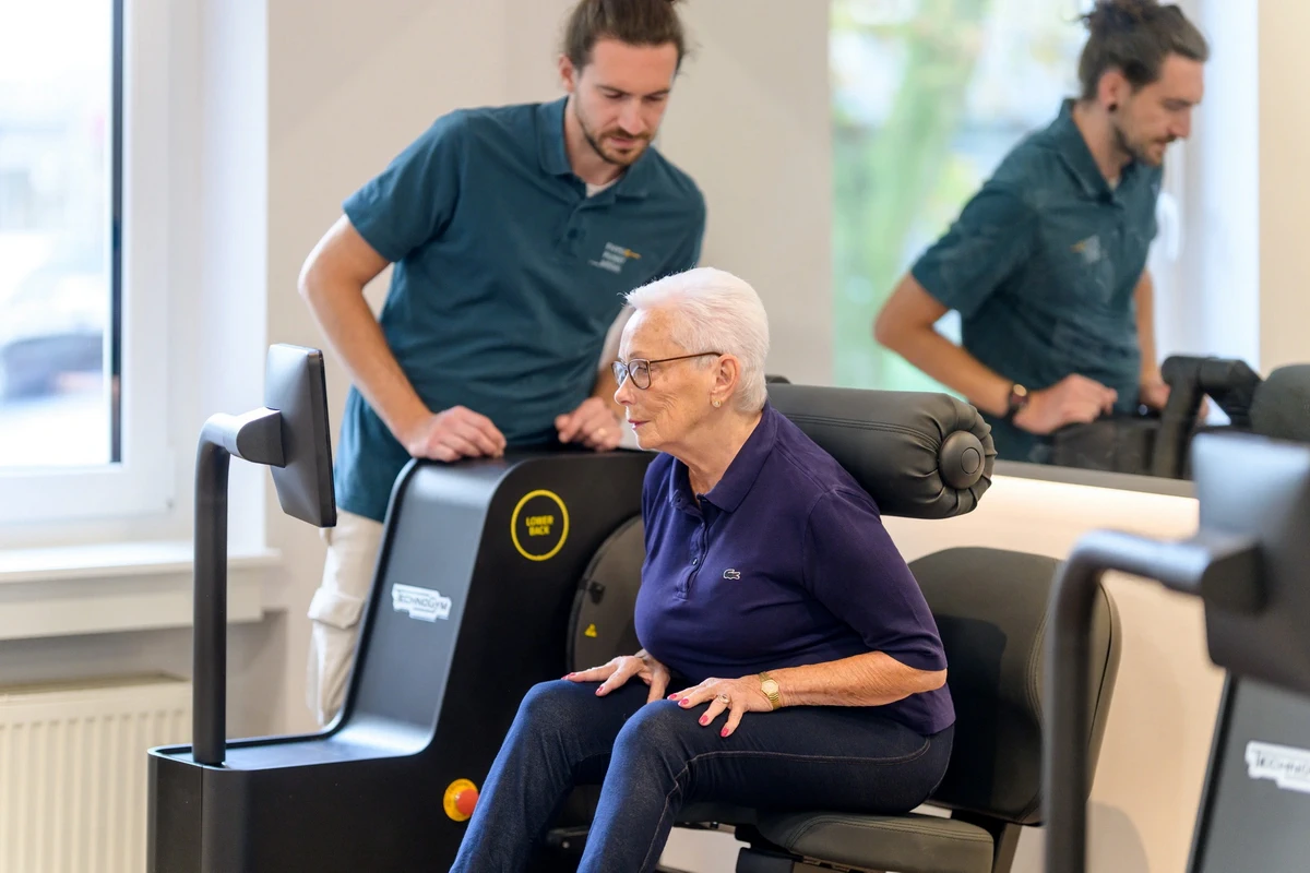 Seniorin trainiert mit Biostrength-Rückengerät bei PhysioPunkt Brühl unter physiotherapeutischer Betreuung