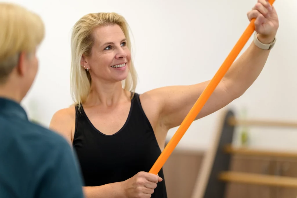 Patientin trainiert mit Theraband unter Anleitung bei PhysioPunkt Brühl