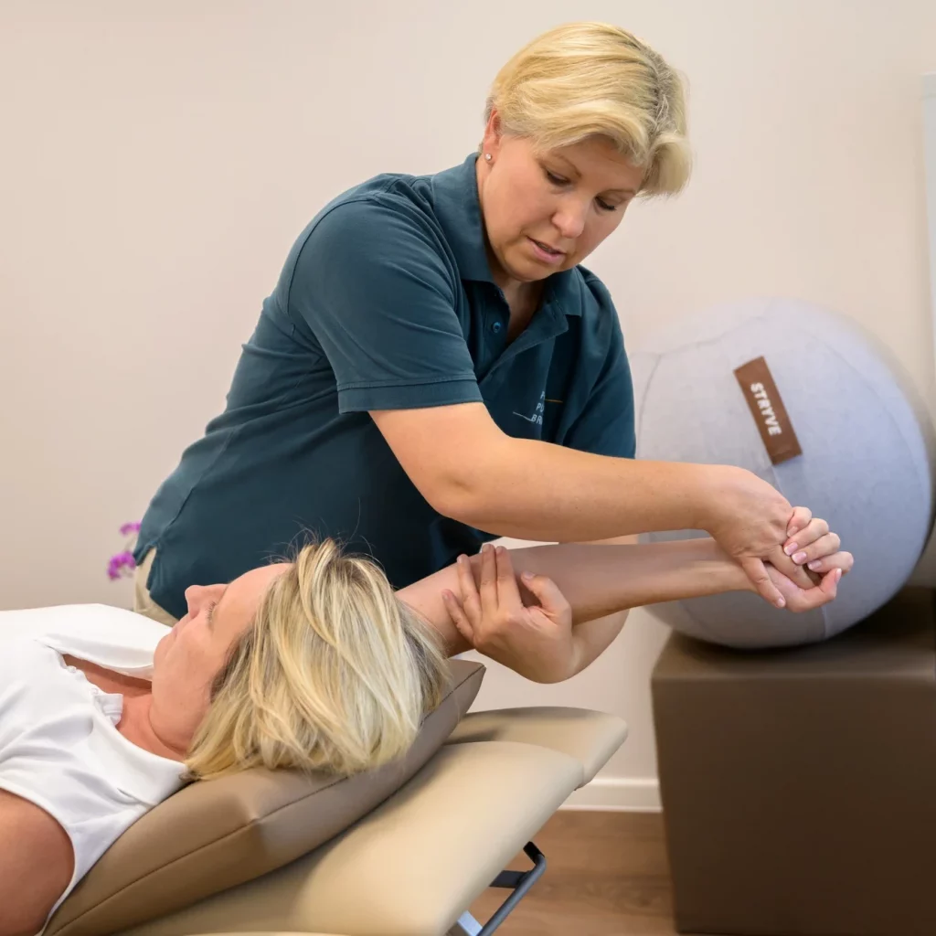Physiotherapeutin unterstützt Patientin mit PNF-Übung am Arm bei PhysioPunkt Brühl