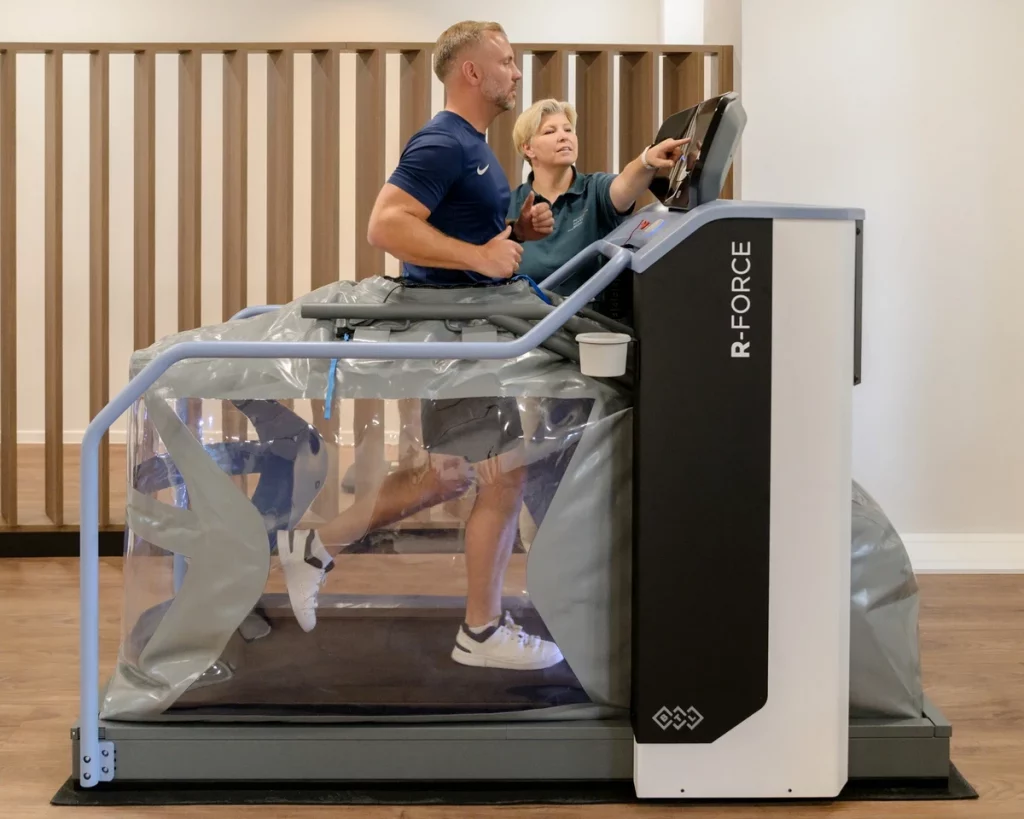 Patient trainiert auf dem R-Force Anti-Schwerkraft-Laufband bei PhysioPunkt Brühl unter Anleitung einer Physiotherapeutin