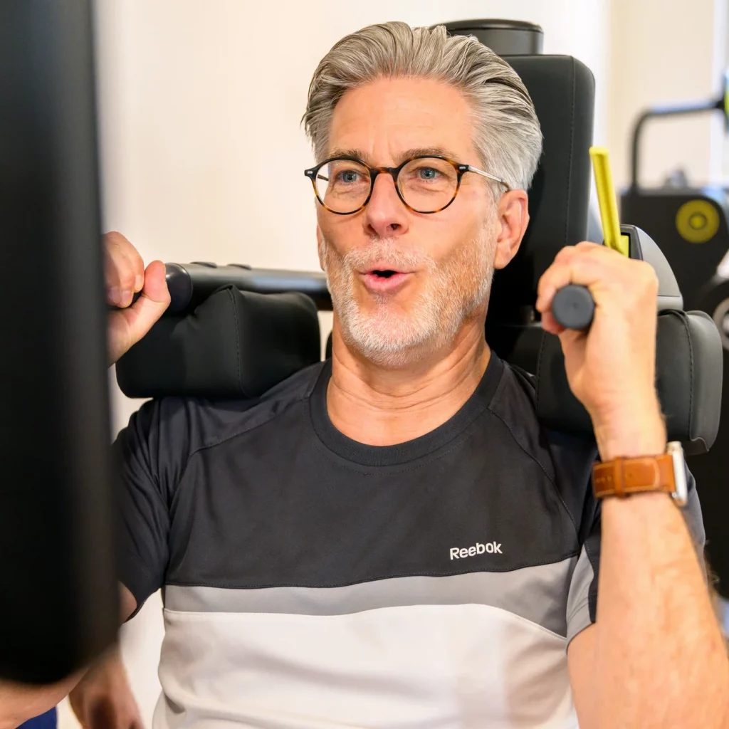 Patient trainiert an einem Biostrength-Gerät bei Physiopunkt Brühl unter physiotherapeutischer Anleitung für Kraft und Stabilität