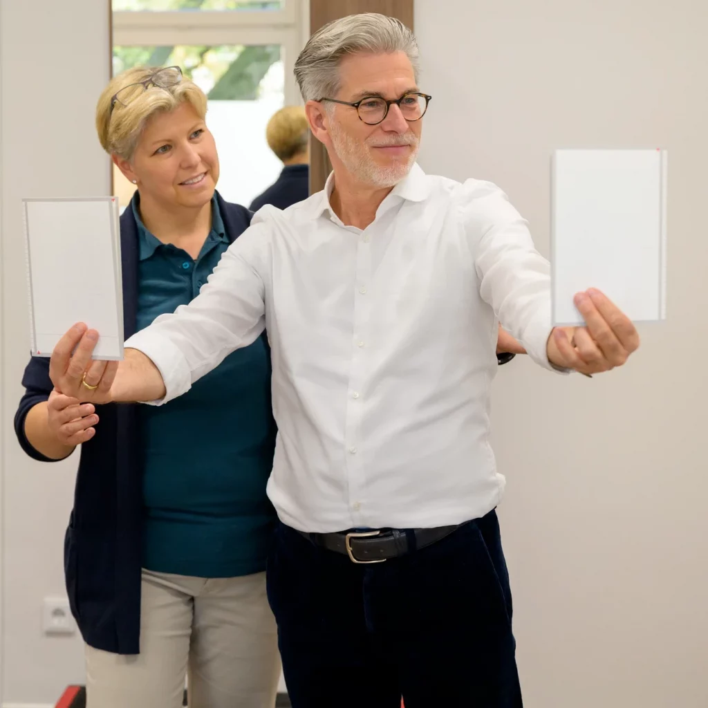 Physiotherapeutin bei PhysioPunkt Brühl zeigt Patient gezielte Augen- und Kopfbewegungen zur Gleichgewichtsschulung in der Schwindeltherapie.