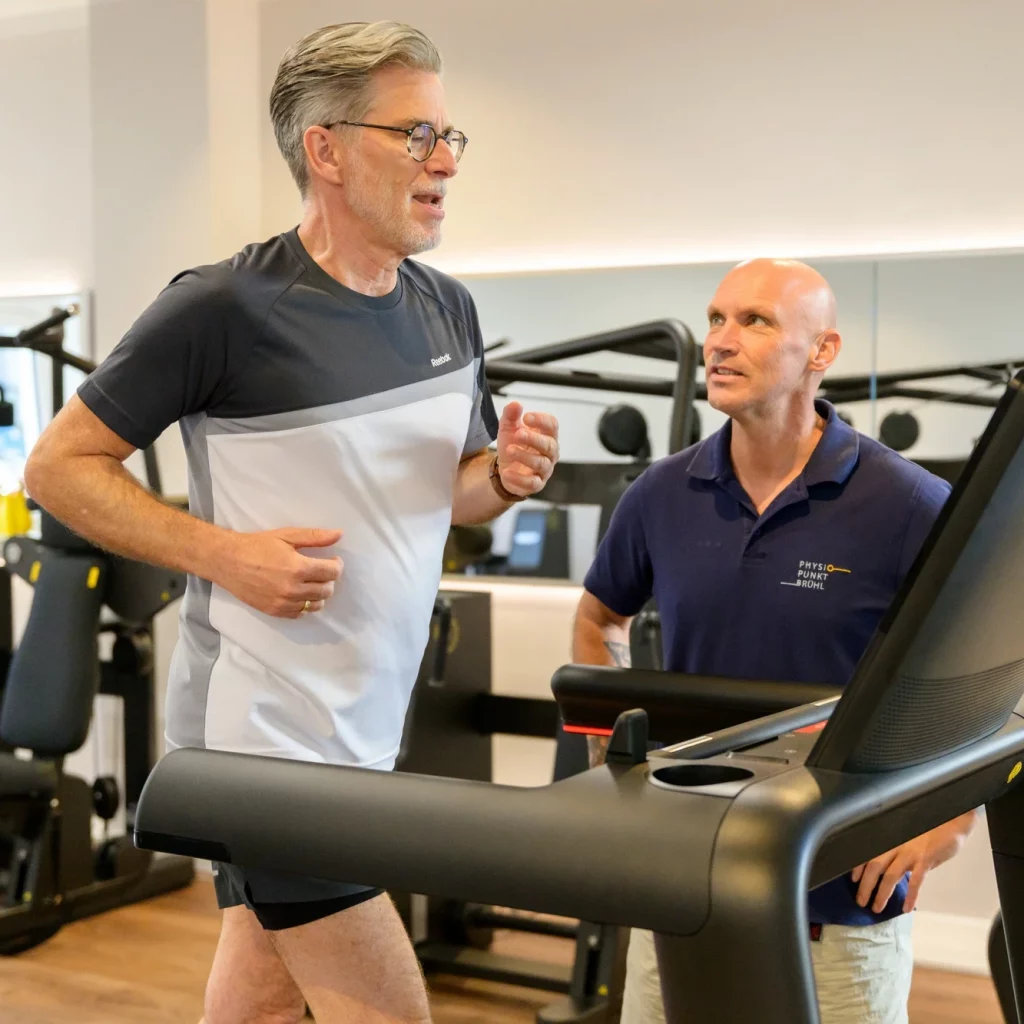 Patient trainiert unter therapeutischer Anleitung auf dem Laufband im Rahmen der T-RENA-Reha-Nachsorge bei PhysioPunkt Brühl.